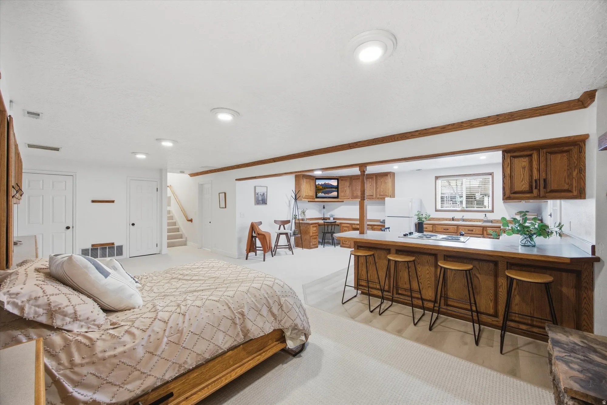 Bedroom featuring crown molding, freestanding refrigerator, bar, and a closet