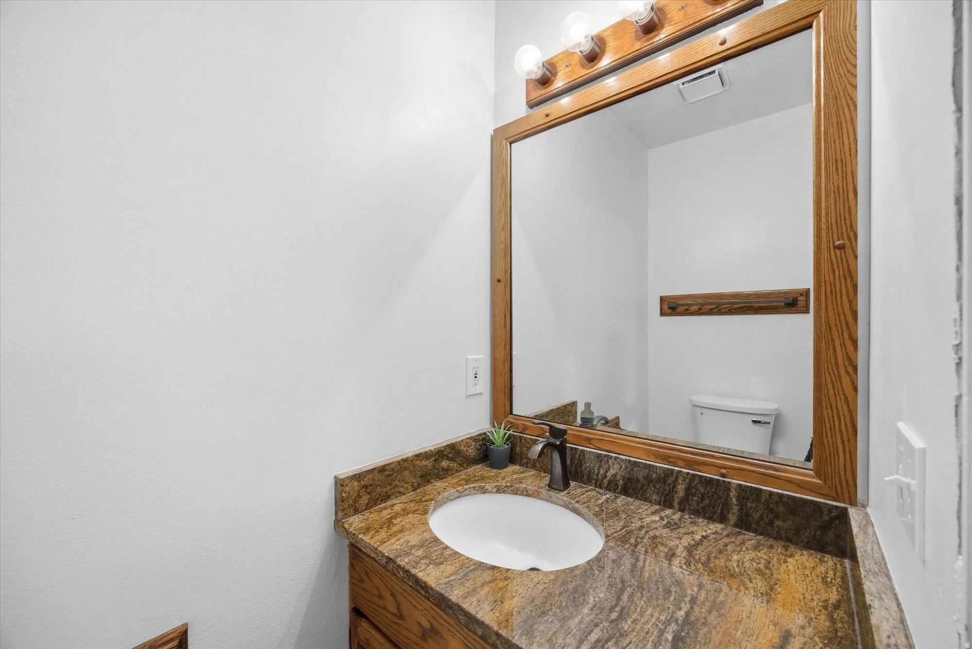 Half bathroom with vanity and toilet