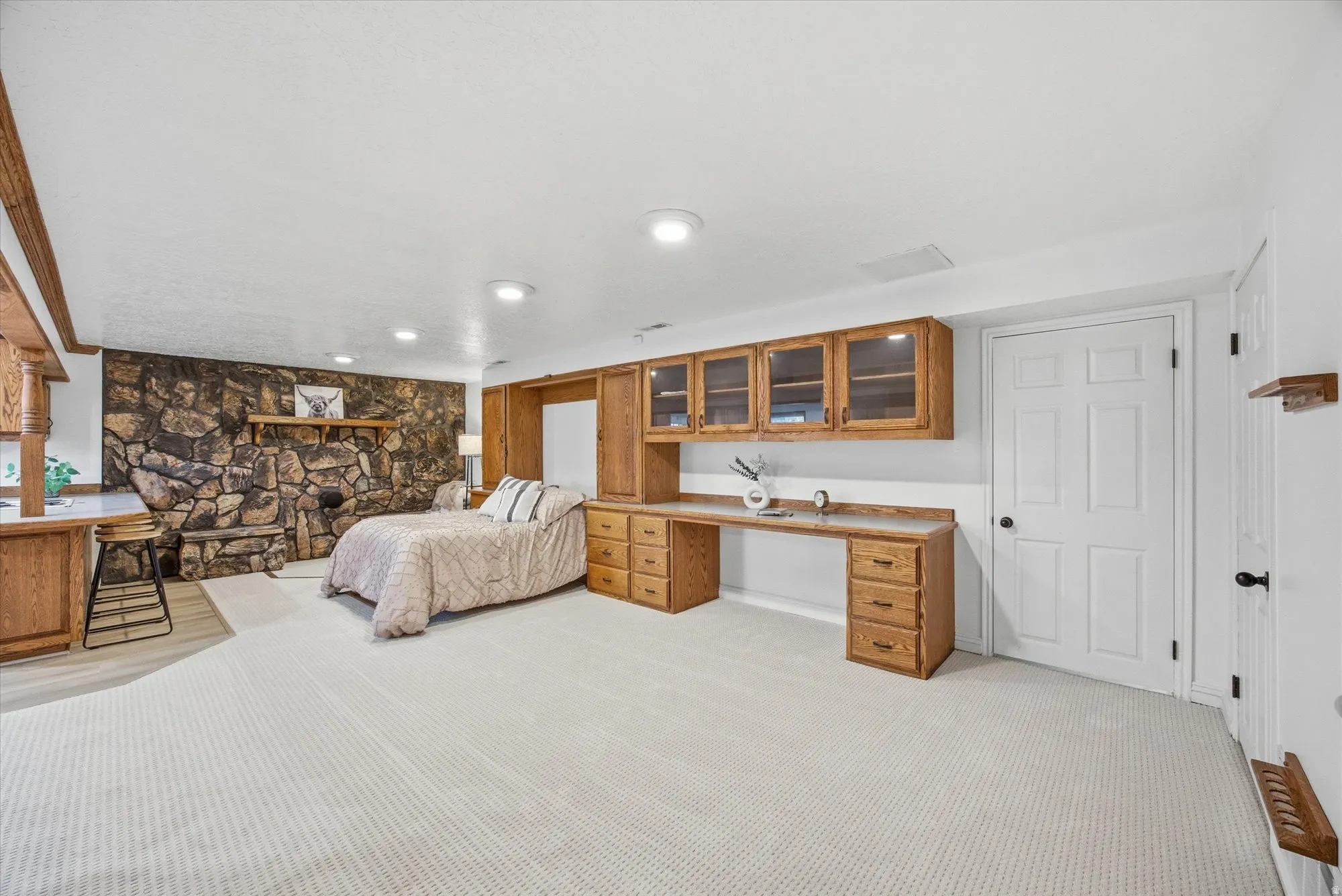 Bedroom featuring light carpet, built in desk, and recessed lighting