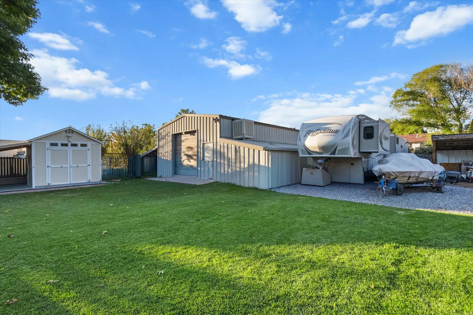 Rear view of property featuring an outbuilding, storage shed and yard