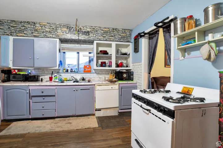 Kitchen featuring white appliances, open shelves, dark wood finished floors, and decorative backsplash
