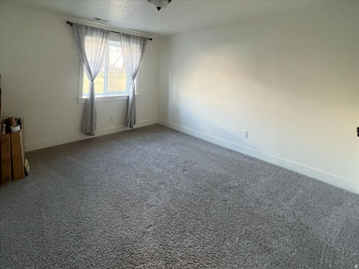 Spare room featuring carpet floors and baseboards