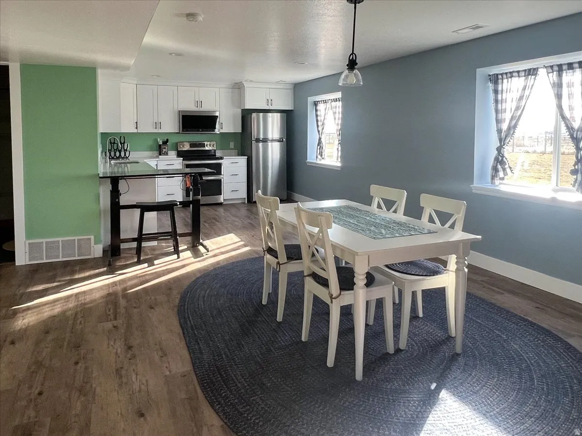 Dining room with dark wood finished floors and baseboards