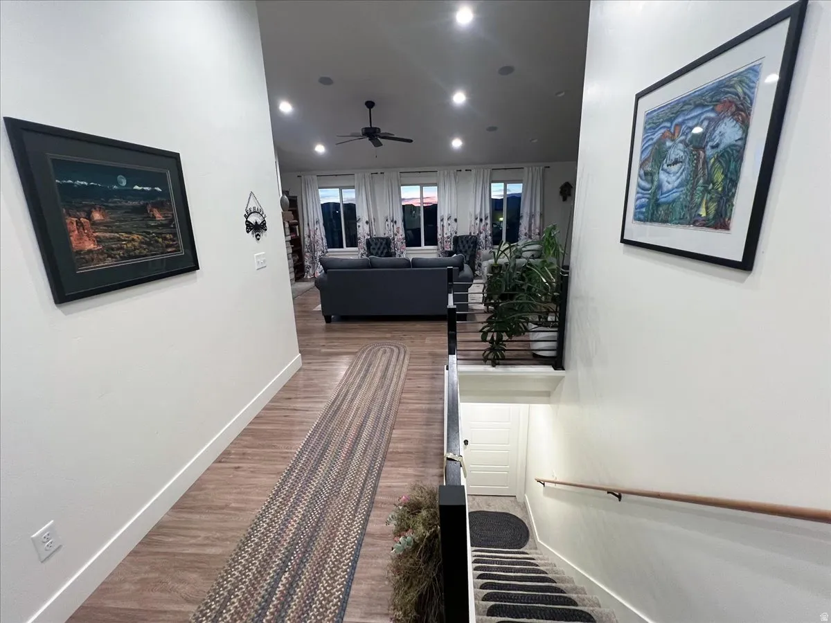 Hall with dark wood-type flooring and recessed lighting