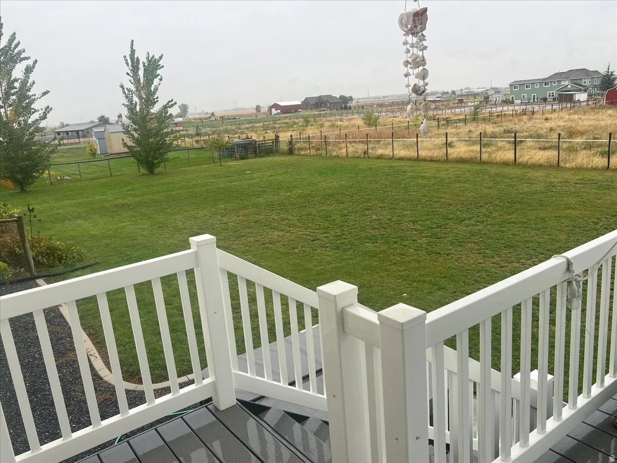 Fenced backyard featuring a deck and a view of countryside