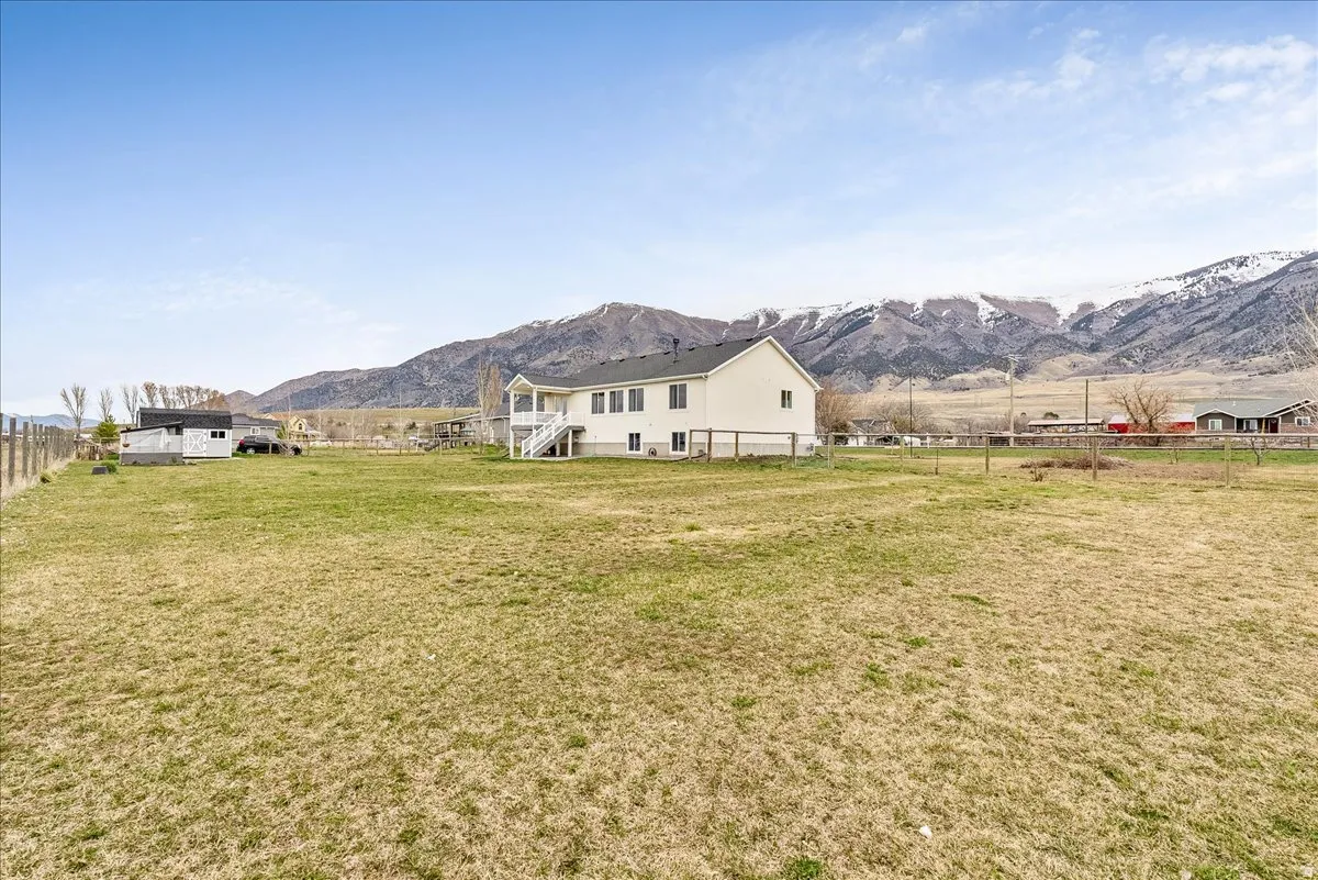 Back of property with a mountain view and a view of rural / pastoral area