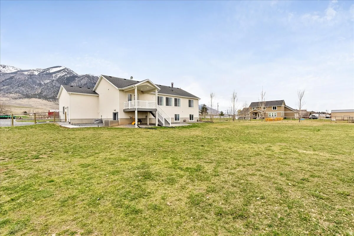 Back of property with a fenced backyard, a patio area, a balcony, and a mountain view