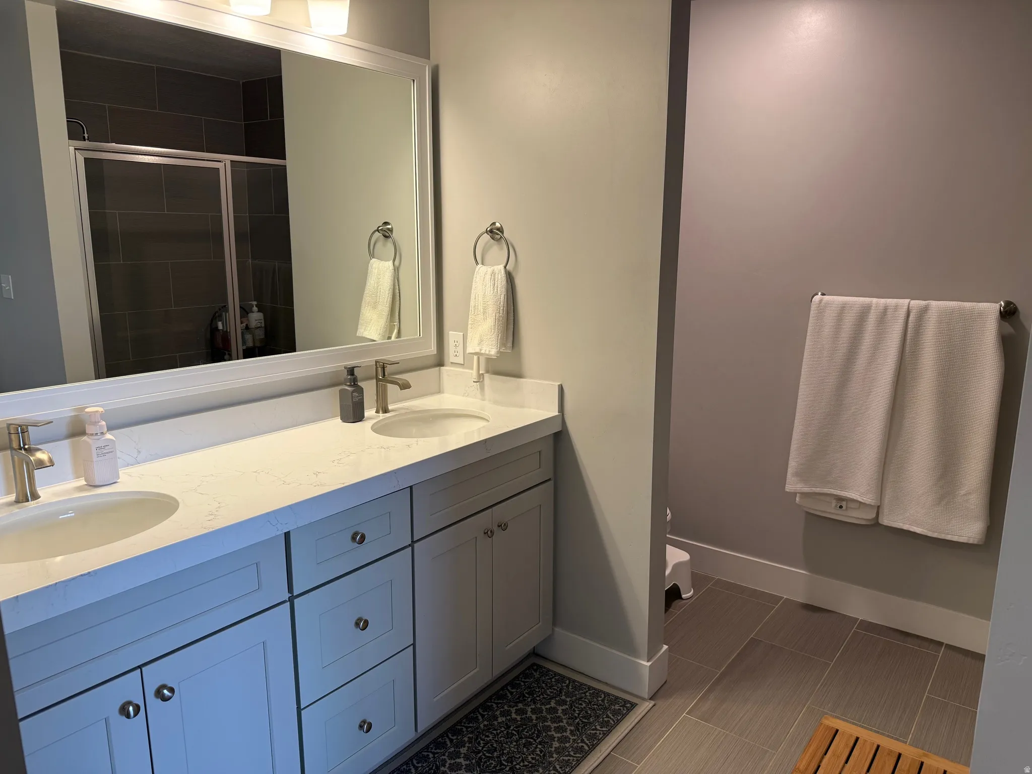 Master bathroom featuring double vanity and a shower stall