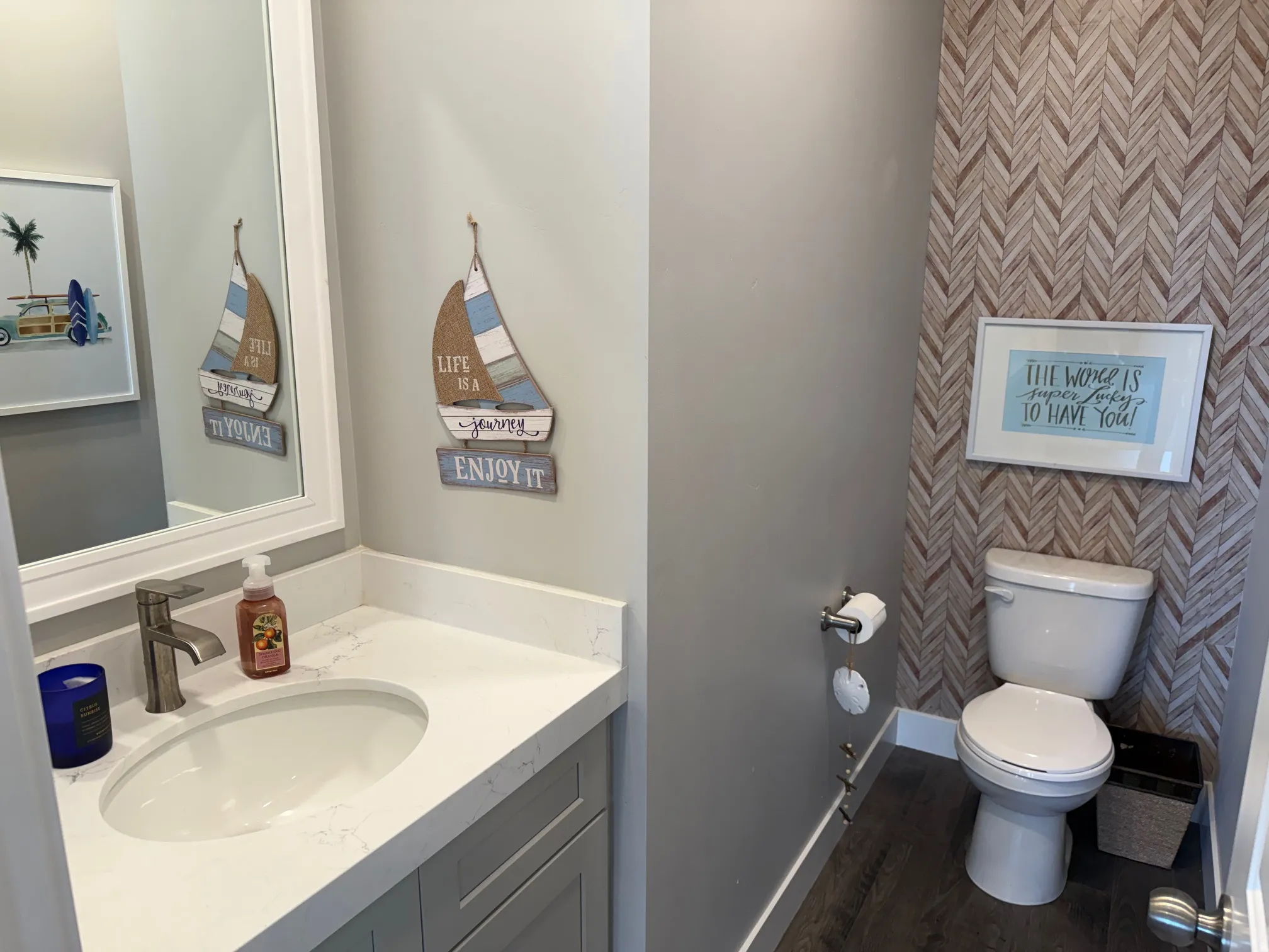 Half bath with vanity, wallpapered walls, and dark wood-style flooring