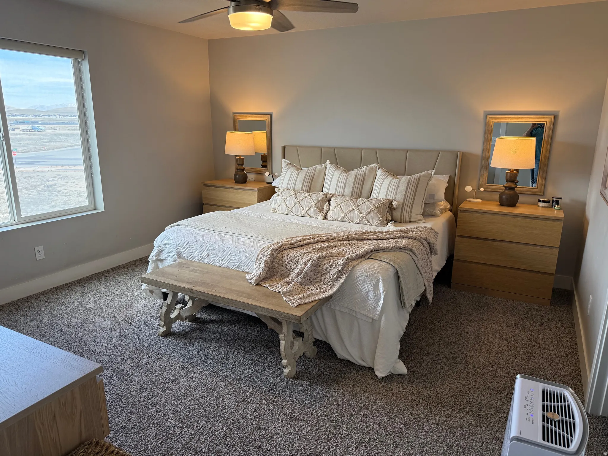 Master bedroom with a ceiling fan and dark carpet, mountain views