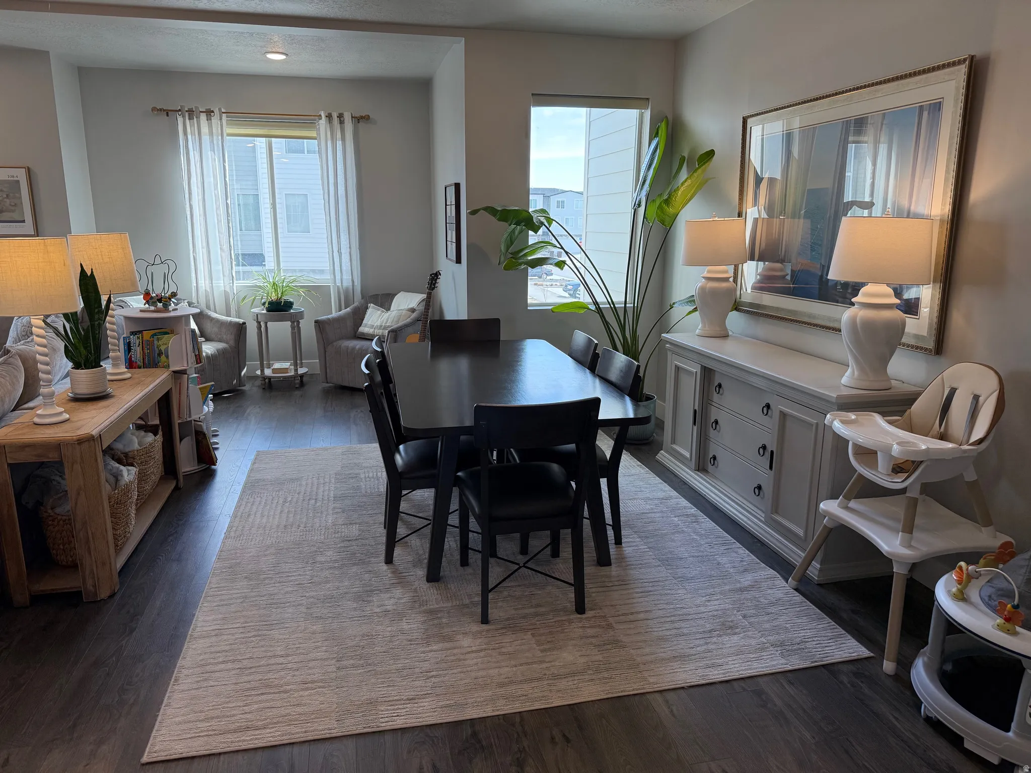 Large Dining room with dark wood-style floors, mountain views, natural light.