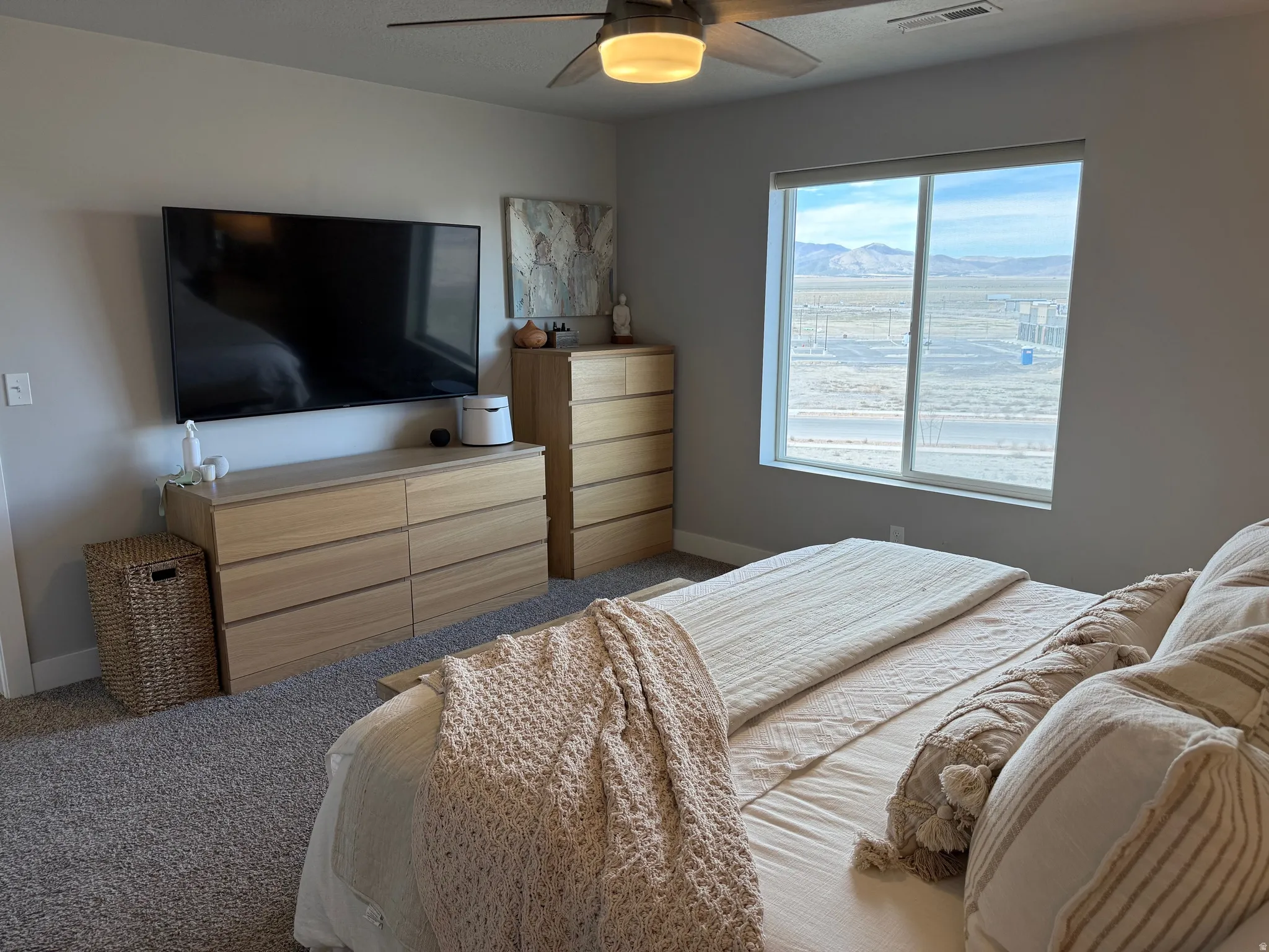 Master bedroom featuring ceiling fan and dark colored carpet, mountain views