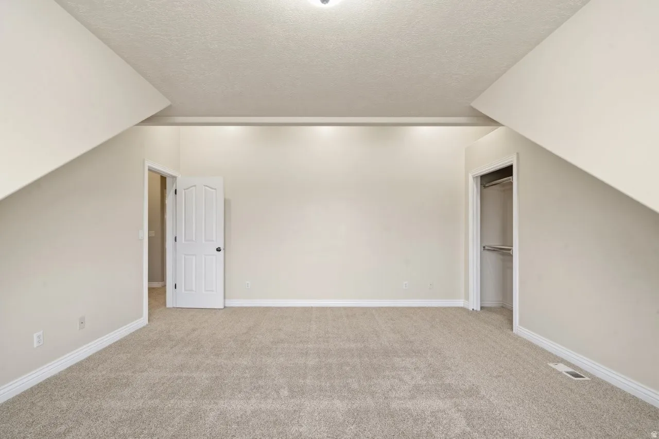 Bonus room featuring light colored carpet