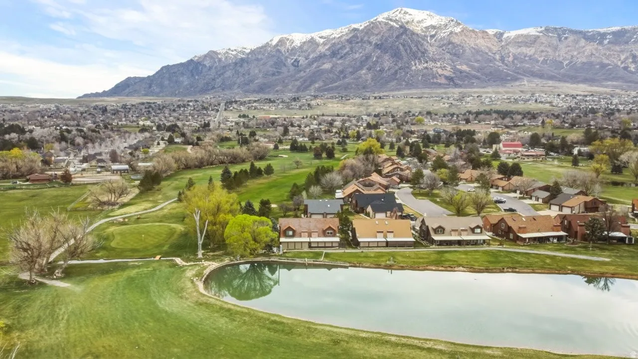 Aerial perspective of suburban area featuring a golf course, and a water and mountain view