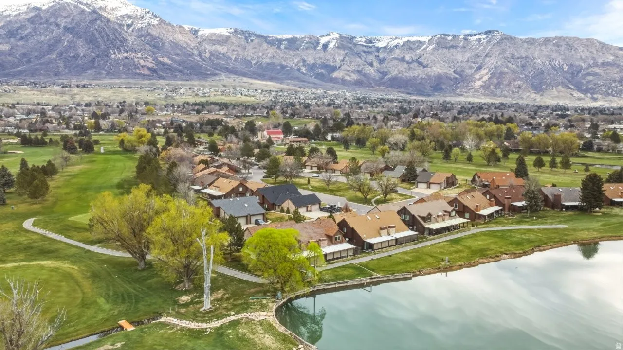 Aerial view of residential area featuring a golf course and a water and mountain view