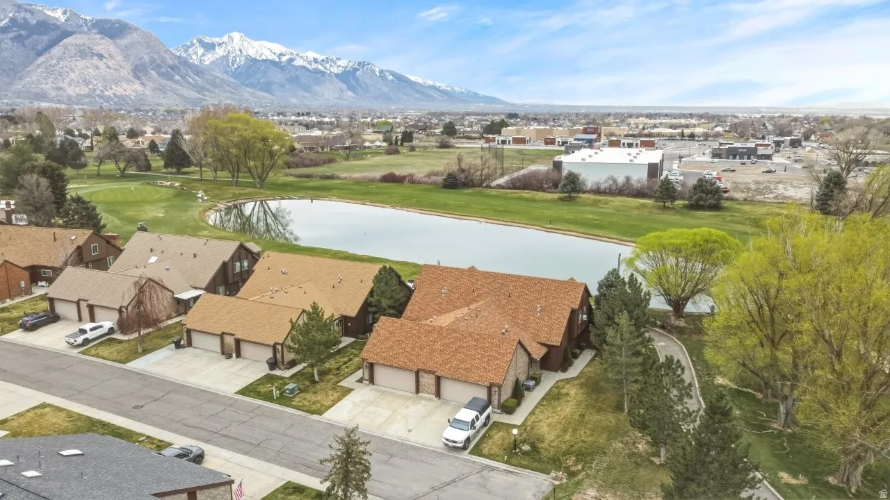 Aerial perspective of suburban area with a water and mountain view and a golf course