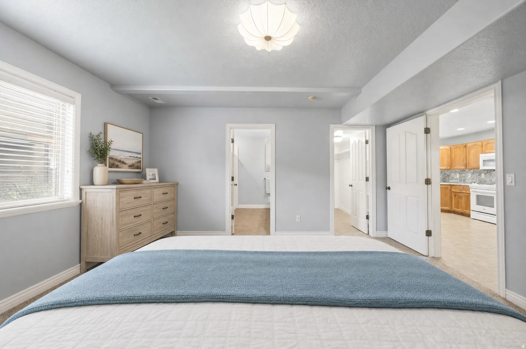 Carpeted room with light gray walls, a window with blinds, and a decorative ceiling light fixture