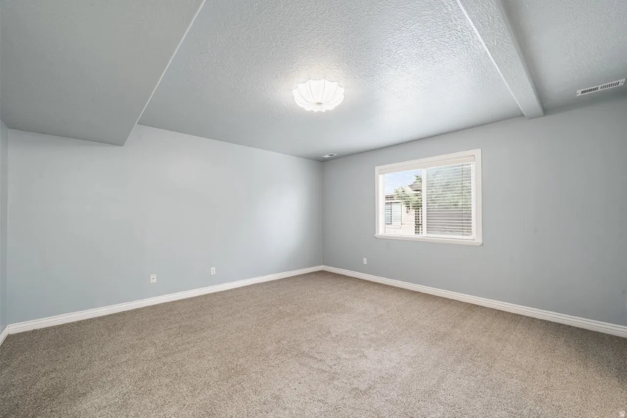 Bedroom featuring a textured ceiling and light colored carpet