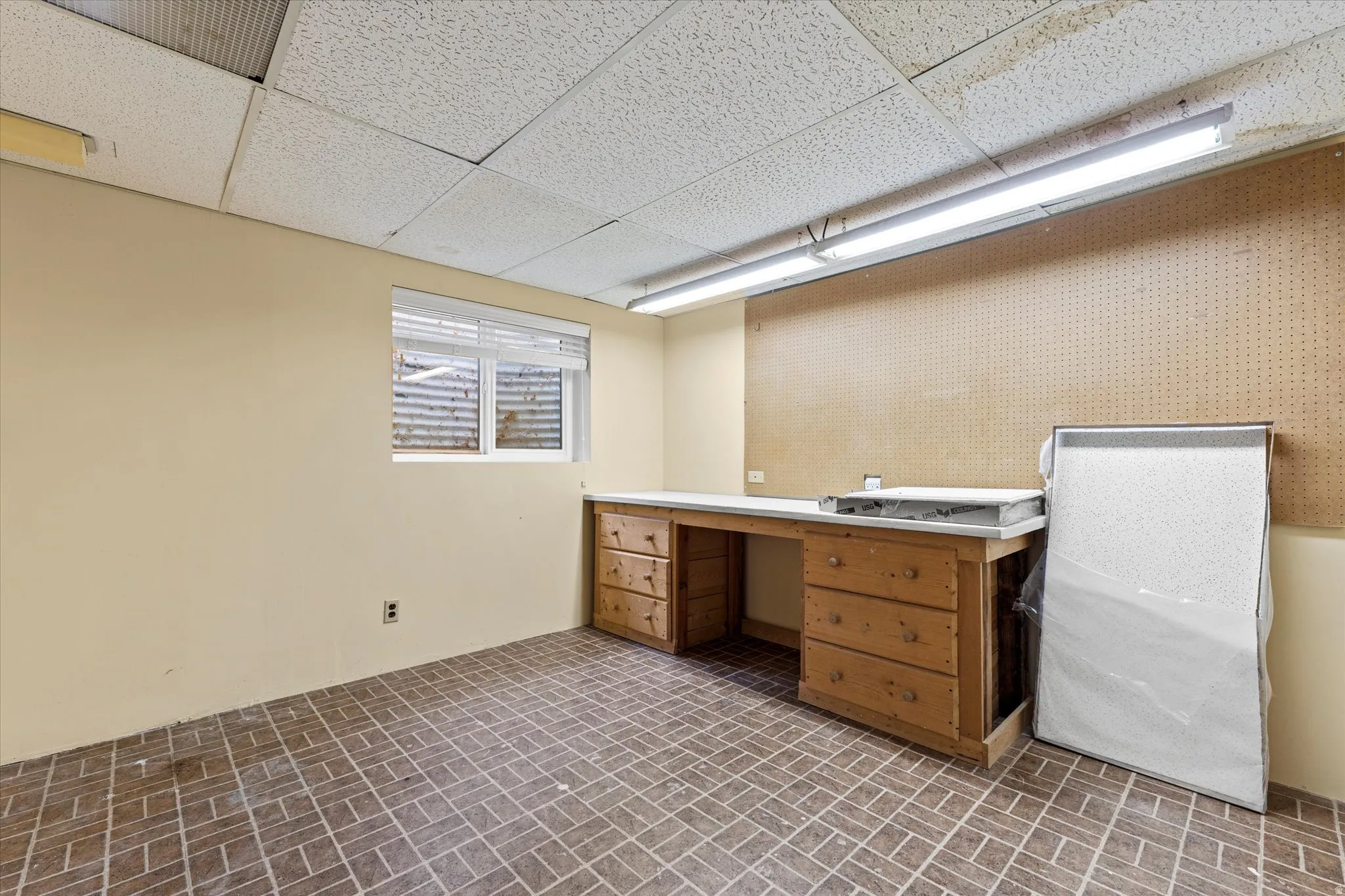 Dedicated workspace with built-in counters, cabinetry, and overhead lighting, perfect for projects, storage, or hobbies.