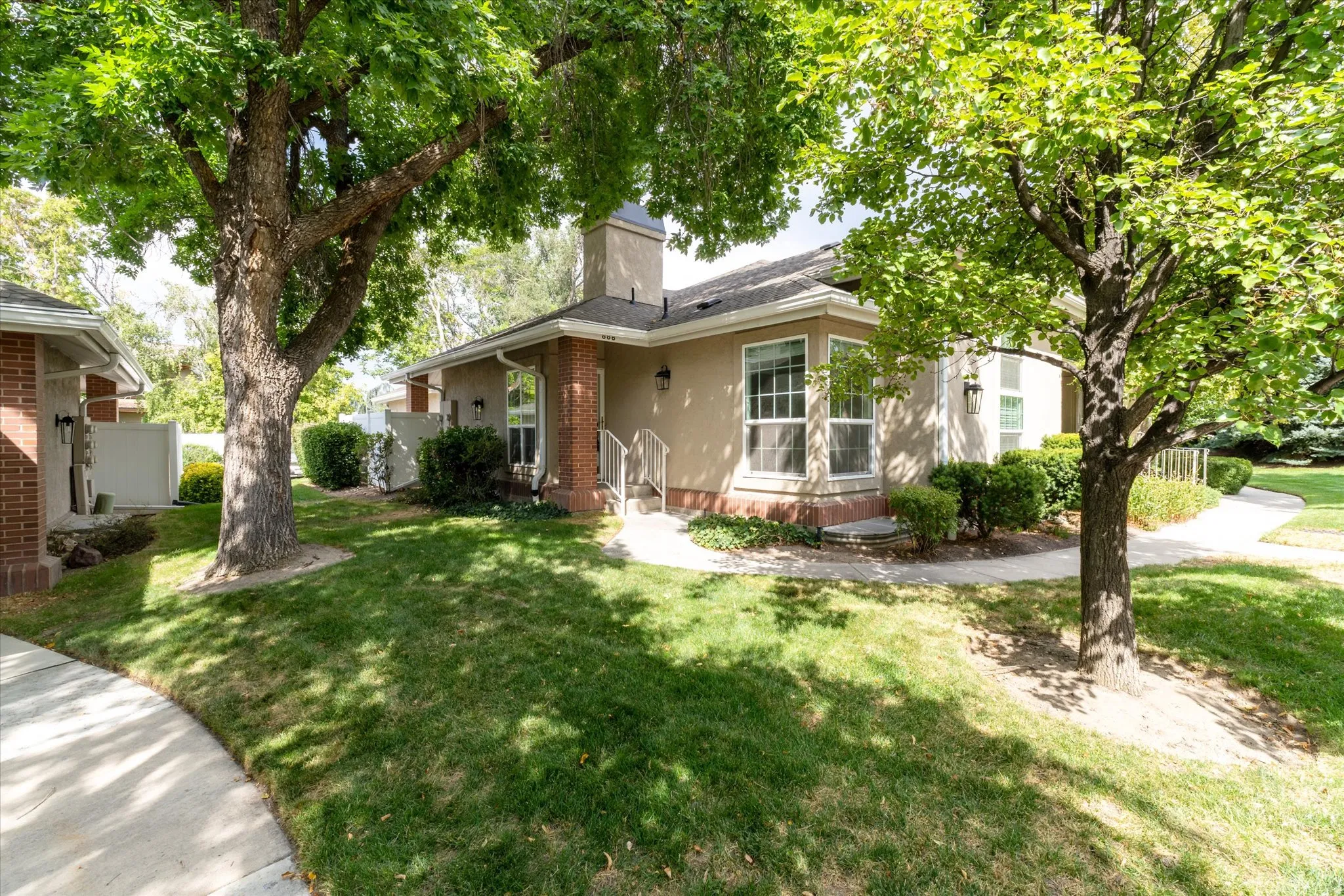 View of front of property with a chimney and brick siding