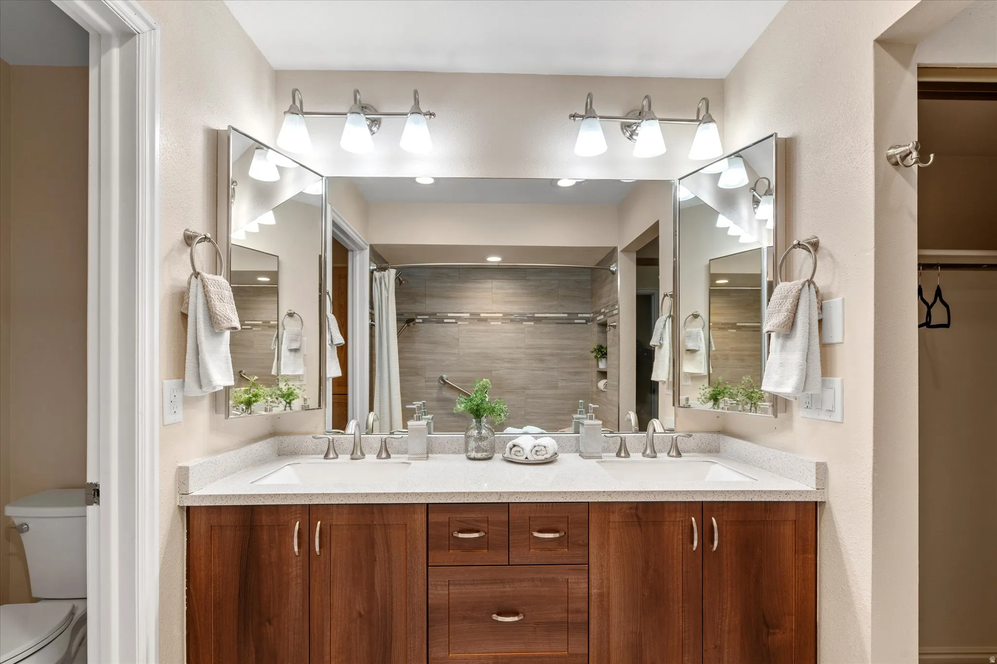 Expansive dual-sink vanity with generous counter space, abundant cabinetry, and updated lighting for a polished, functional design.