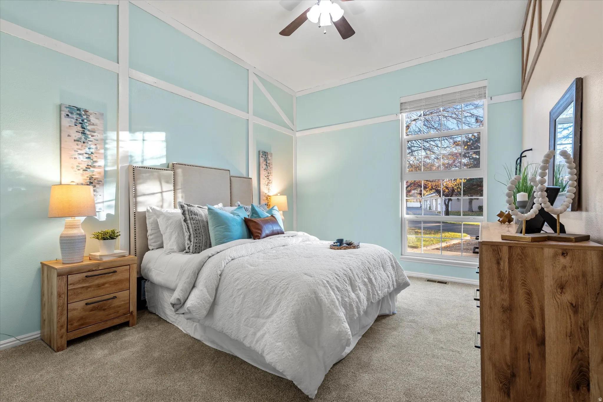 Spacious bedroom with vaulted ceilings, large windows, and soft natural light, creating a calm and inviting retreat.
