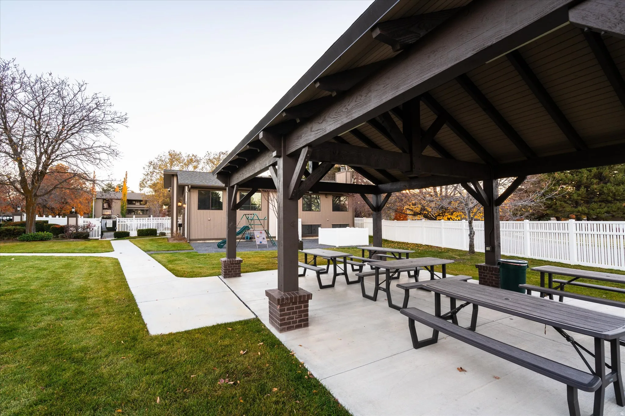 Covered picnic area with multiple seating spaces, perfect for outdoor gatherings, dining, and neighborhood events.
