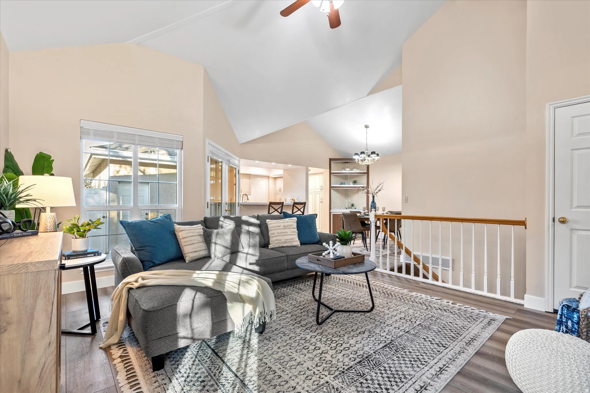 Bright, open living area with vaulted ceilings and large windows that fill the space with natural light, creating an inviting atmosphere for relaxing or entertaining.