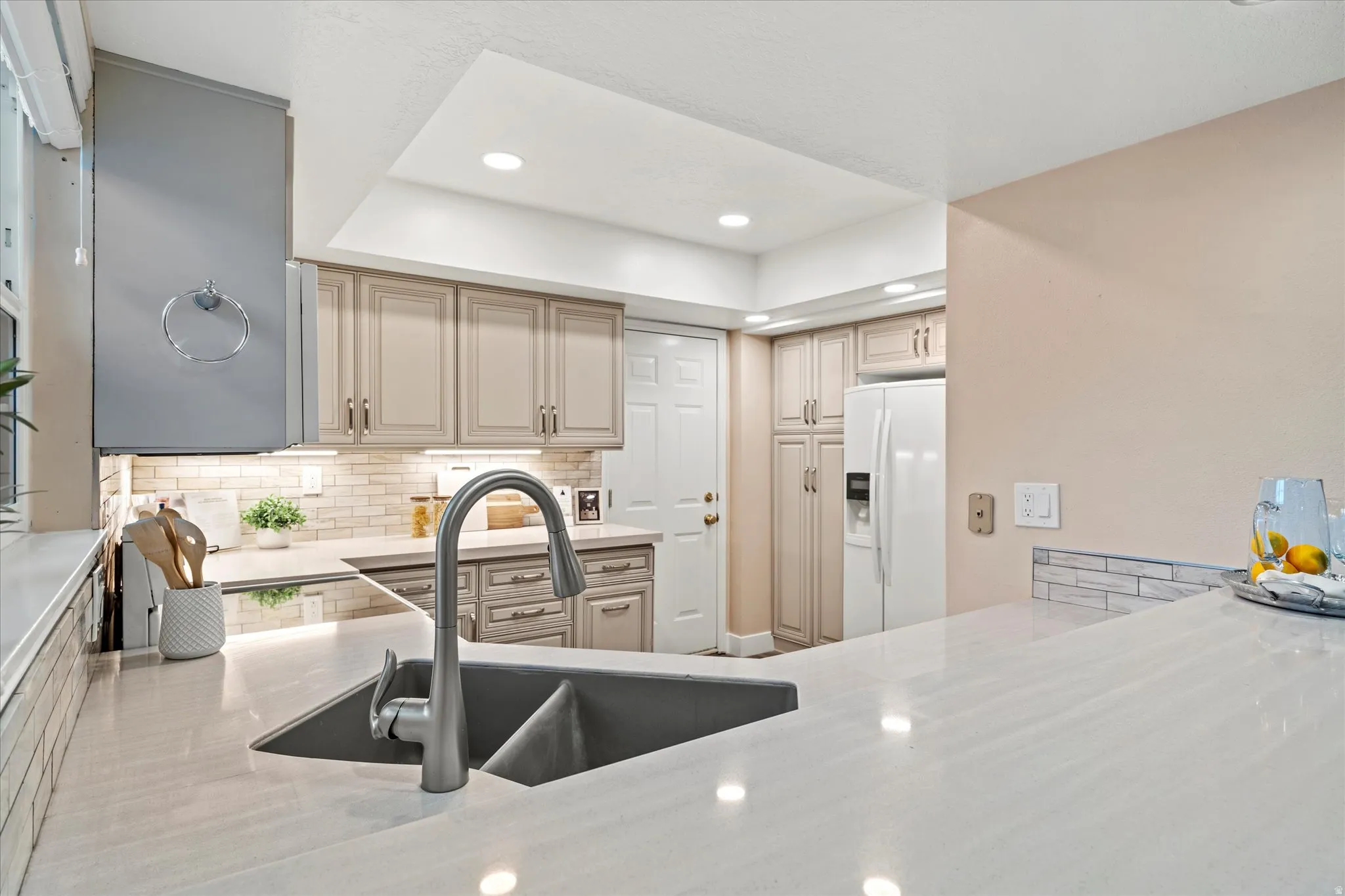 Bright kitchen with sleek solid-surface countertops, under-cabinet lighting, and ample cabinetry, offering both style and functionality.