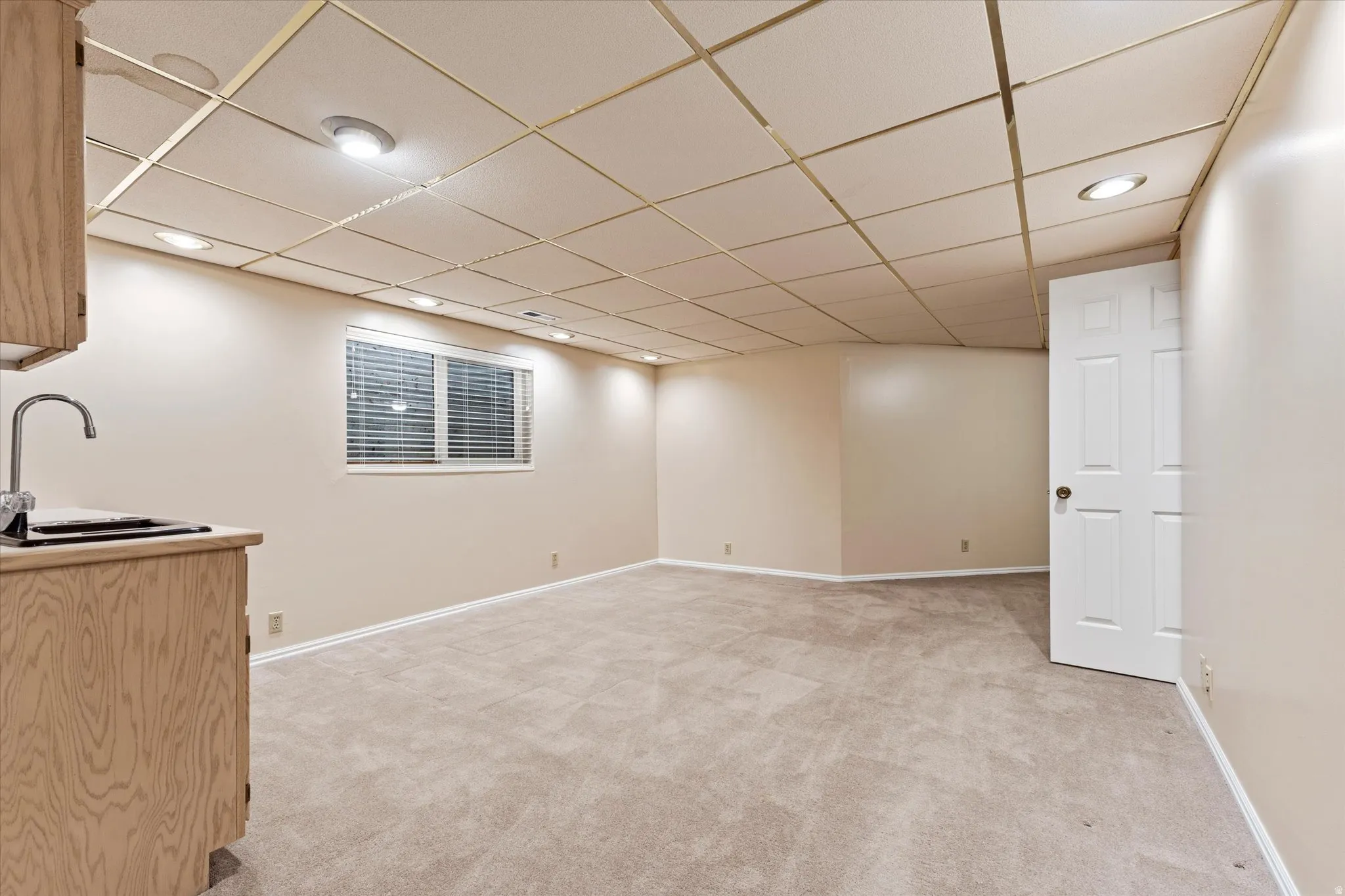 Spacious lower-level living area with recessed lighting and neutral tones, ideal for a media room, game space, or additional lounge area.