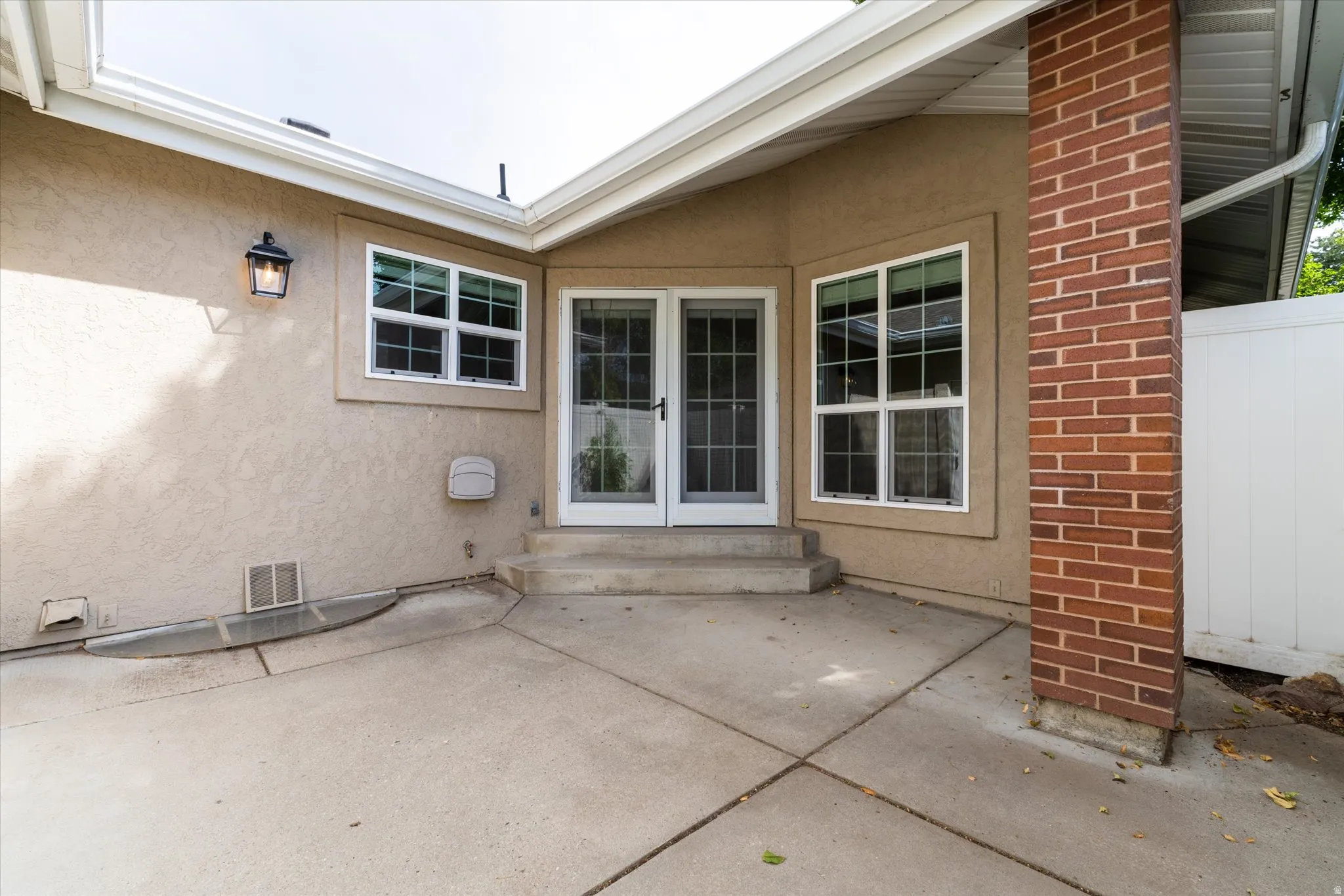 Enclosed patio space with concrete surface and surrounding privacy fencing, ideal for outdoor seating, dining, or low-maintenance enjoyment.