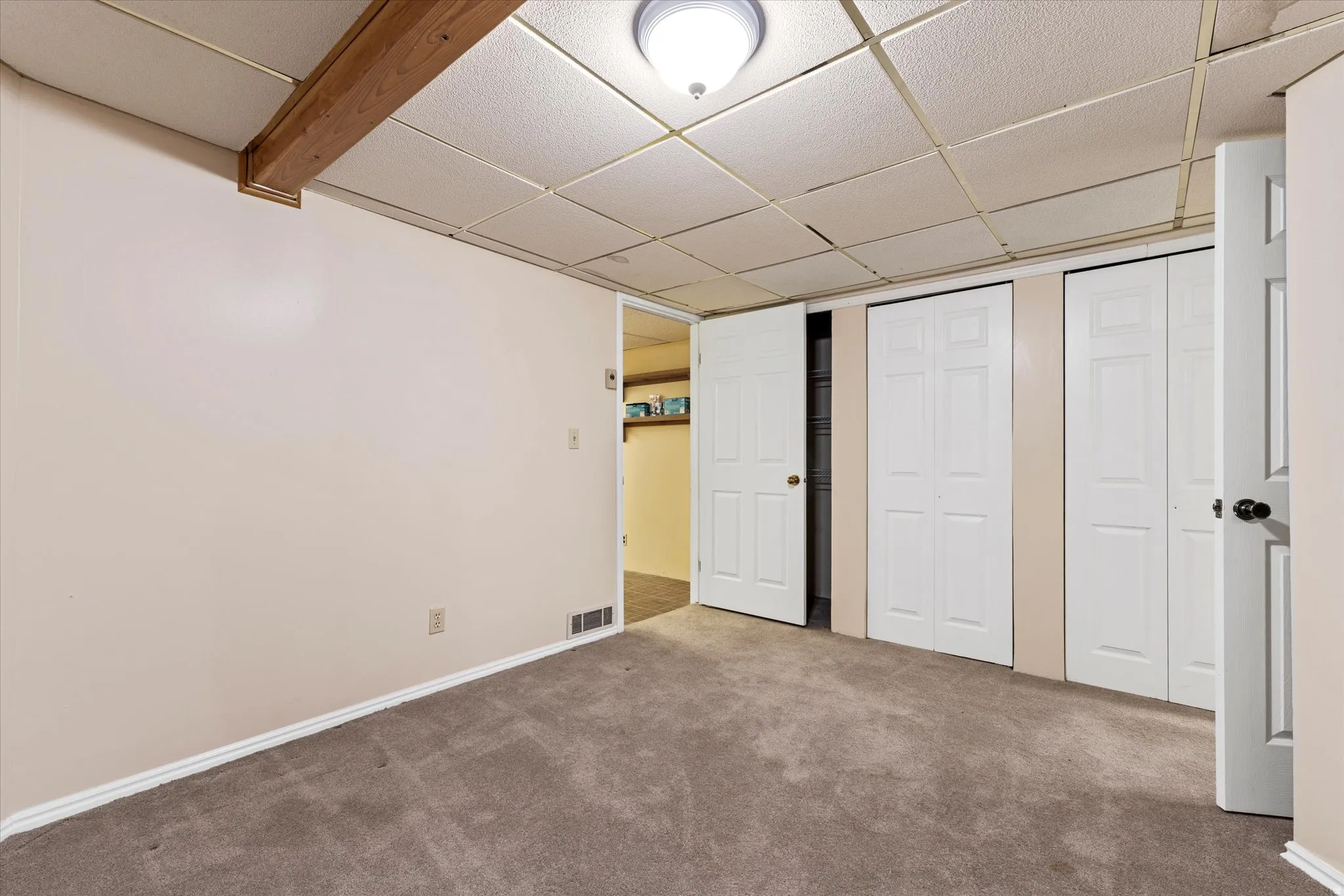 Comfortable lower-level bedroom with closet space and neutral finishes, ideal for guests or additional living flexibility.