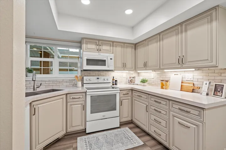 Efficient U-shaped layout with abundant cabinetry and workspace, complemented by modern lighting and a clean, cohesive design.