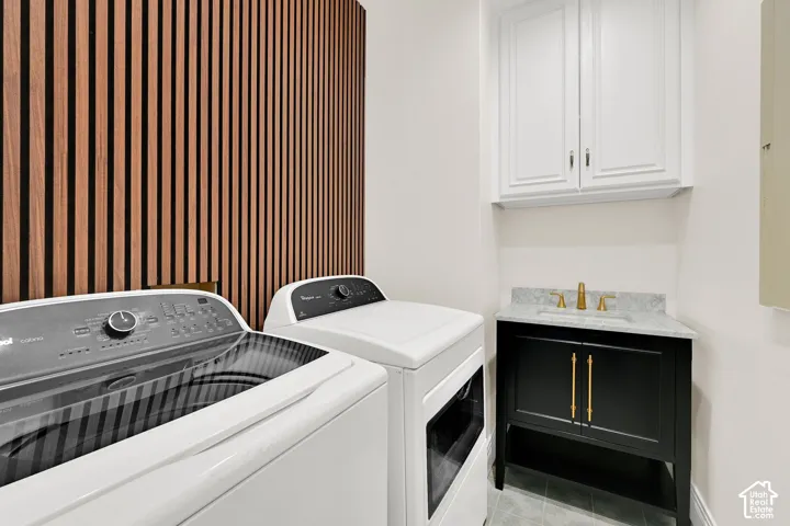 Laundry area featuring cabinet space, washing machine and clothes dryer, and light tile patterned floors