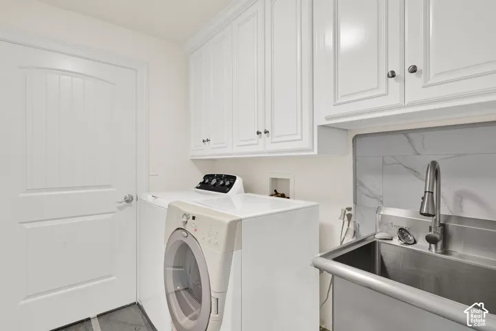 Laundry room featuring separate washer and dryer and cabinet space