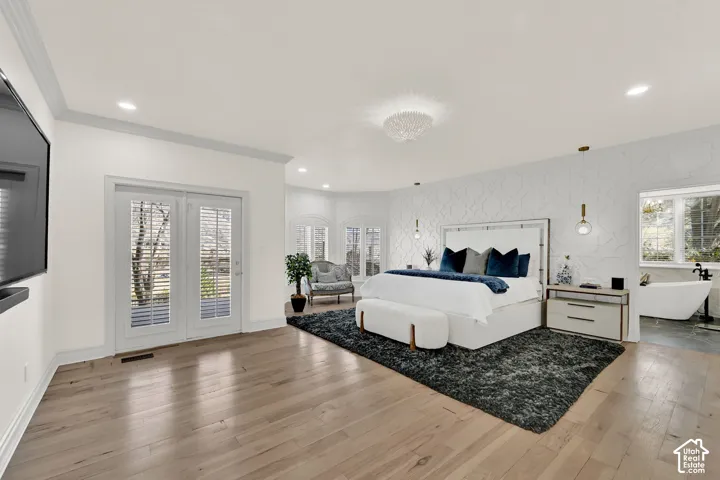 Bedroom with light wood-style floors, access to exterior, crown molding, recessed lighting, and wallpapered walls