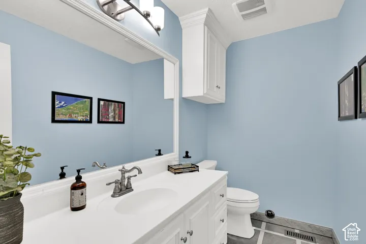Half bathroom featuring vanity and tile patterned floors
