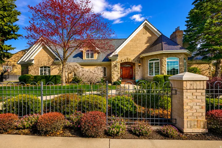 Stone and brick exterior with a prominent arched entry, a turret-style architectural feature, and a slate-style roof
