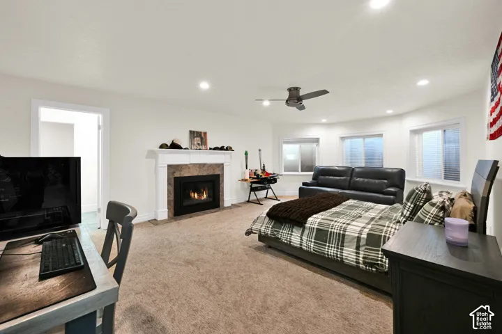 Bedroom with light carpet, a fireplace, recessed lighting, and ceiling fan