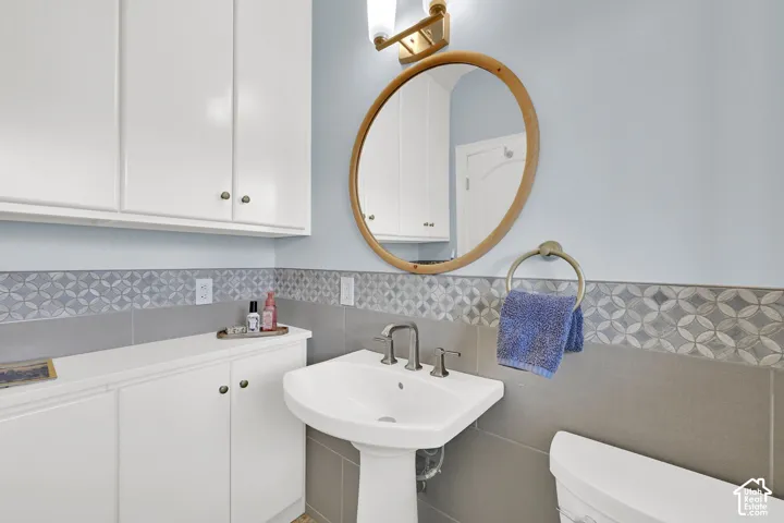 Bathroom with tile walls and a wainscoted wall