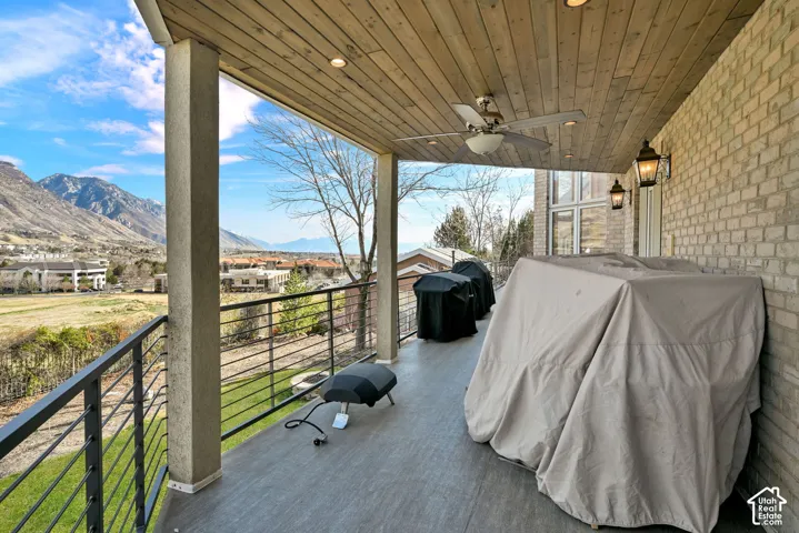 View of patio with area for grilling, a mountain view, a ceiling fan, and a residential view