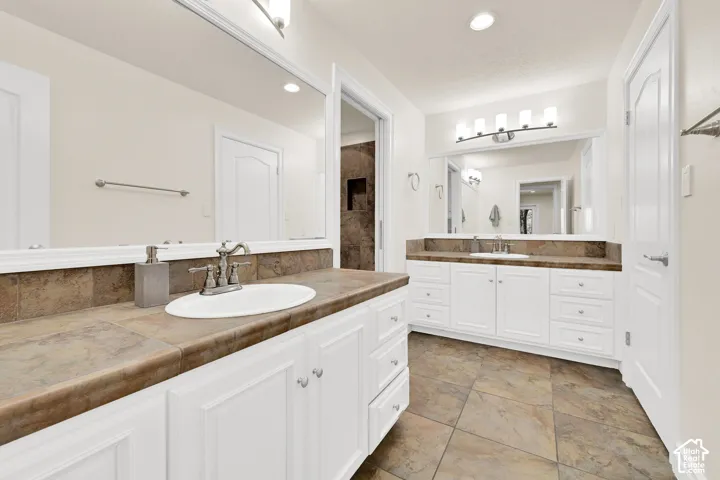 Full bath with two vanities and recessed lighting