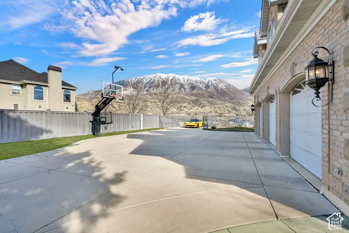 View of patio / terrace featuring a mountain view, a garage, and driveway