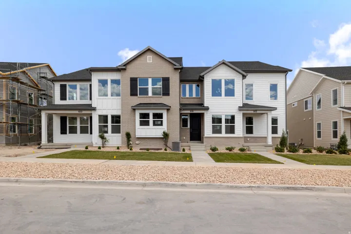 Modern townhome exteriors featuring white siding and light brick accents