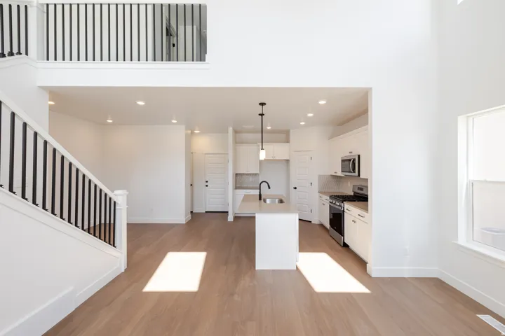 Spacious interior featuring high ceilings, wood-finish flooring, and white walls