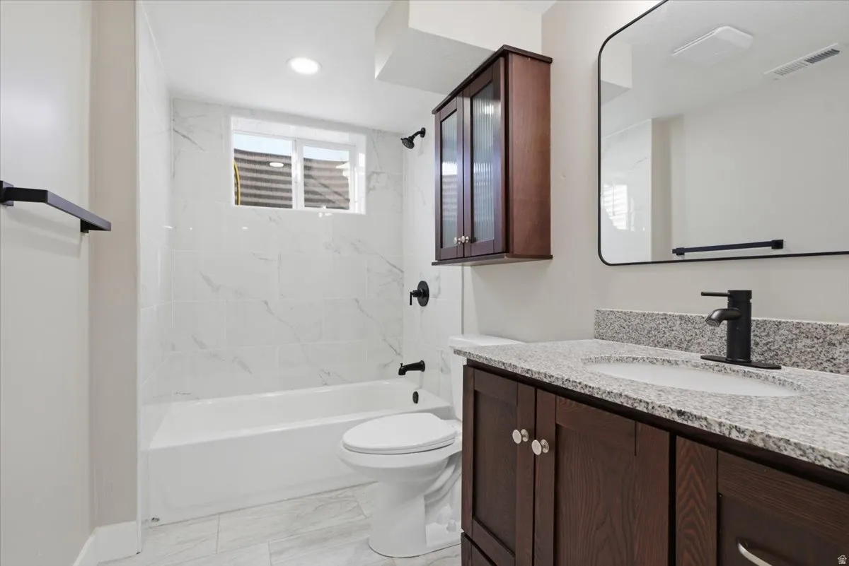 Bathroom with vanity, tub / shower combination, and light marble finish floors