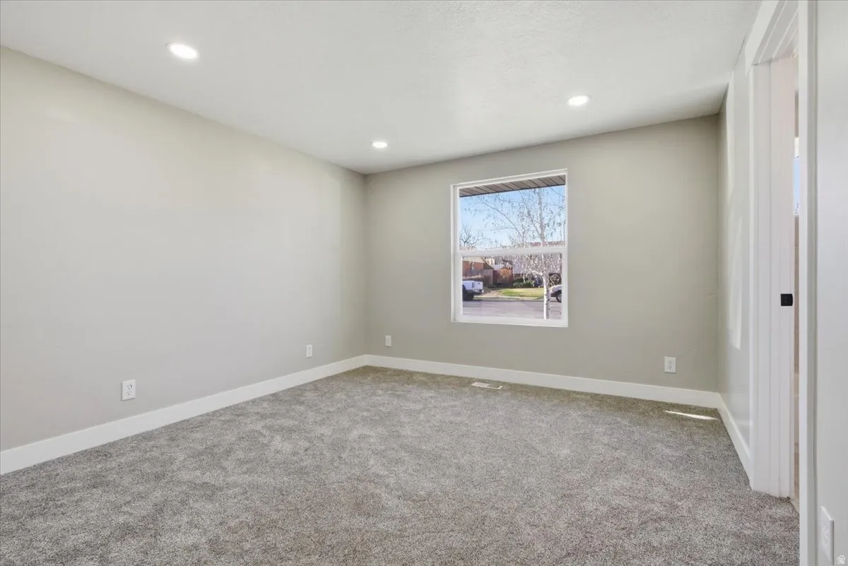 Carpeted spare room featuring baseboards and recessed lighting