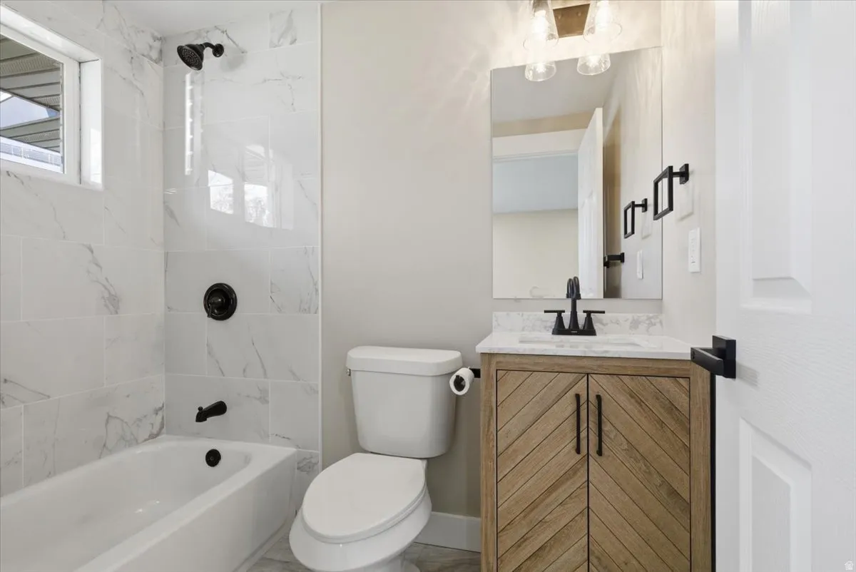 Full bath featuring vanity and washtub / shower combination