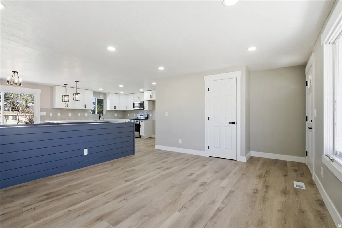 Unfurnished living room featuring light wood-type flooring and recessed lighting
