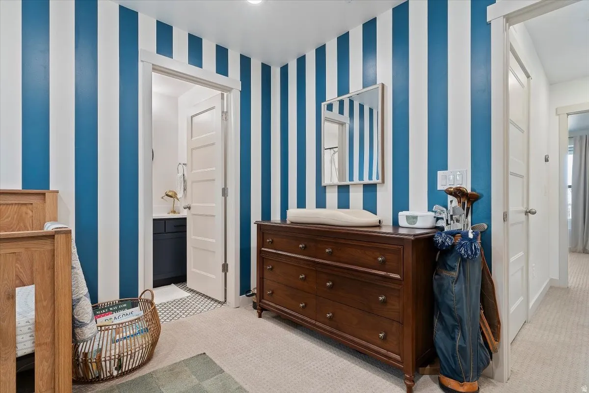 Bedroom with light colored carpet and ensuite bath
